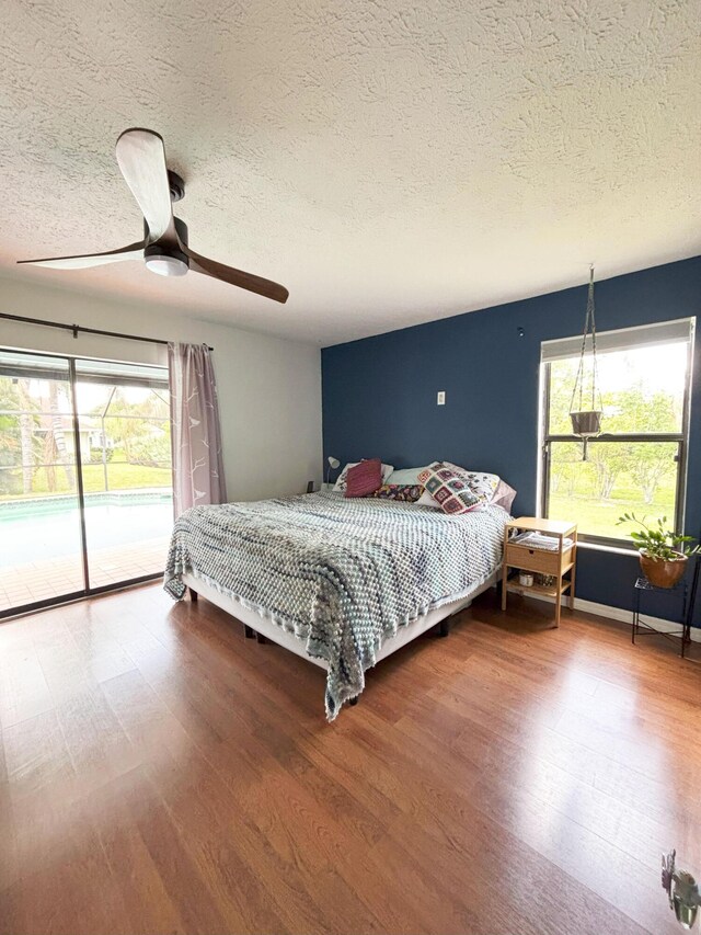1826 SW Stratford Way, Palm City, FL 34990 - bedroom with access to exterior, wood finished floors, a textured ceiling, and a ceiling fan