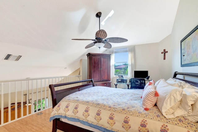 bedroom featuring visible vents, wood finished floors, a ceiling fan, and vaulted ceiling