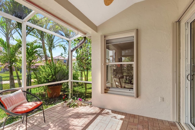 unfurnished sunroom with lofted ceiling and ceiling fan