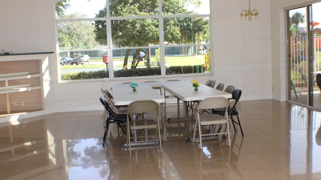 dining area featuring light tile patterned floors, baseboards, and an inviting chandelier