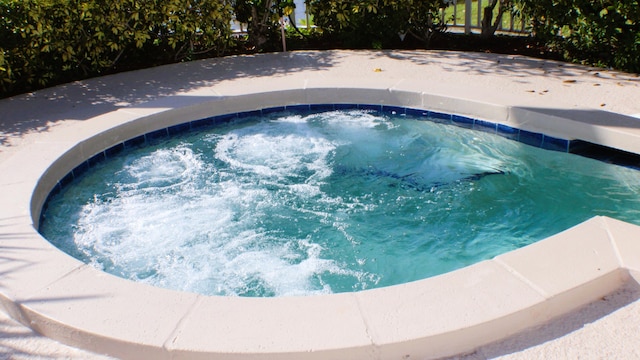 view of swimming pool with an in ground hot tub