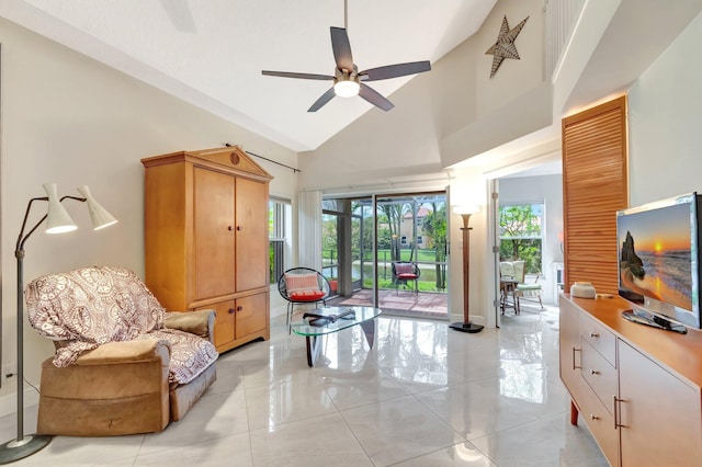 sitting room with baseboards, plenty of natural light, high vaulted ceiling, and ceiling fan