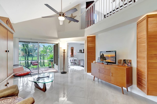 living area featuring a high ceiling, light tile patterned floors, and a ceiling fan