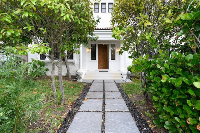 doorway to property featuring stucco siding