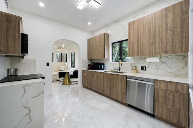 kitchen featuring arched walkways, a sink, marble finish floor, dishwasher, and modern cabinets