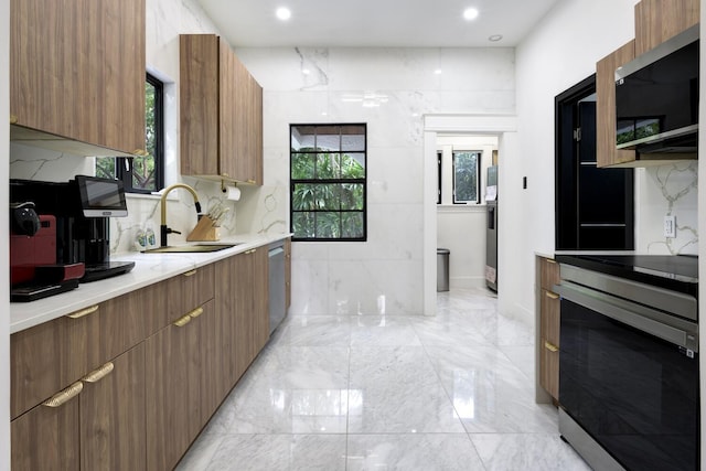 kitchen with plenty of natural light, modern cabinets, stainless steel appliances, and a sink