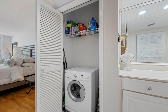 washroom with laundry area, light wood finished floors, visible vents, washer / clothes dryer, and recessed lighting