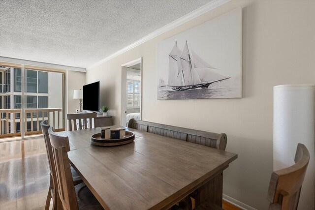 dining room featuring ornamental molding, wood finished floors, visible vents, and baseboards