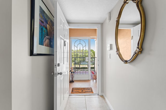 entryway featuring tile patterned flooring, baseboards, and a textured ceiling