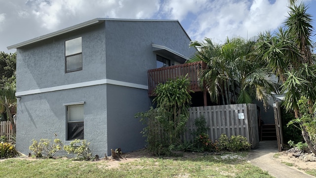 view of property exterior with fence and stucco siding