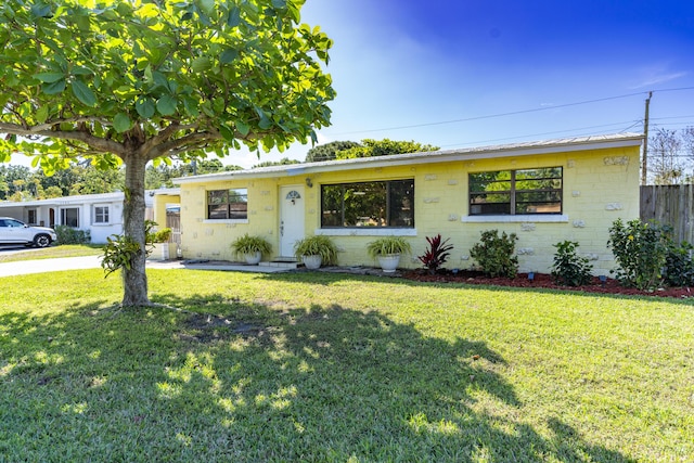 ranch-style house with brick siding, a front yard, and fence