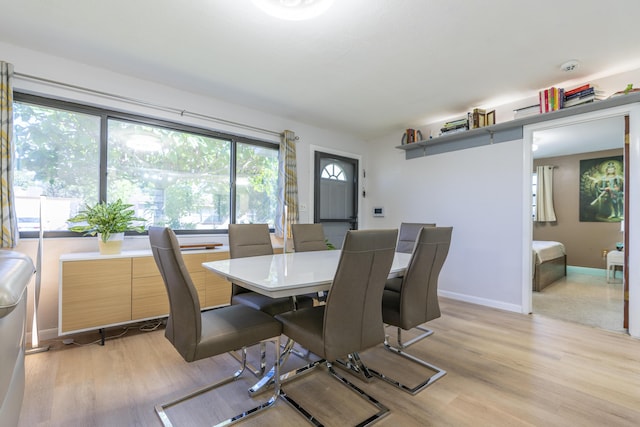 dining area featuring light wood-style flooring and baseboards