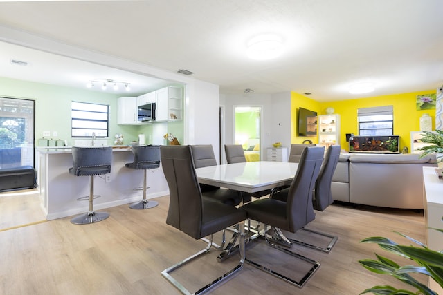 dining area featuring visible vents and light wood-style flooring