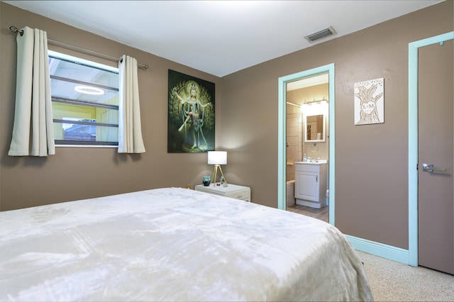 bedroom featuring visible vents, baseboards, and ensuite bath