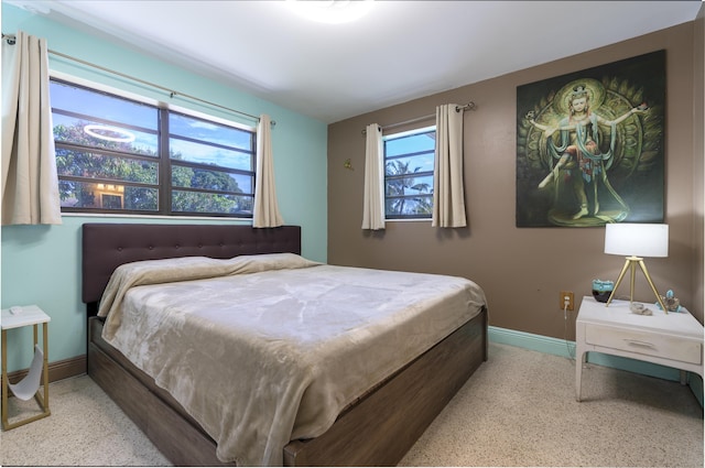 bedroom featuring speckled floor and baseboards