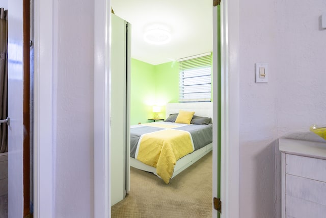 bedroom with a textured wall and carpet floors