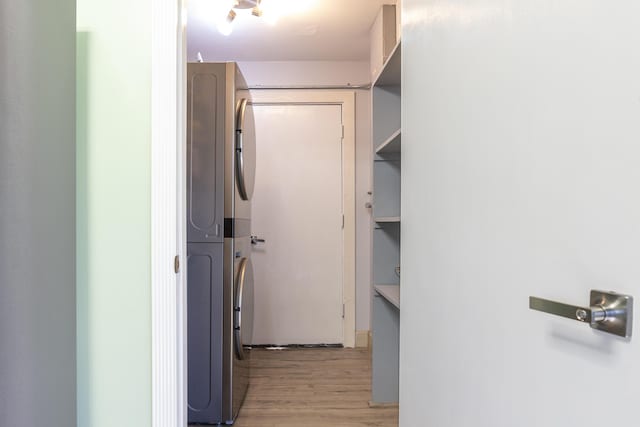 spacious closet featuring light wood finished floors and stacked washing maching and dryer