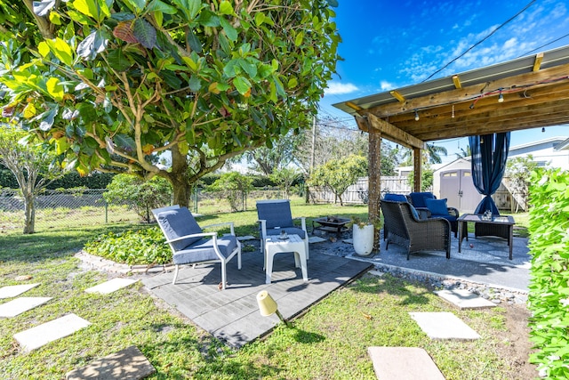 view of patio / terrace featuring a shed, a wooden deck, a fenced backyard, an outdoor structure, and a fire pit