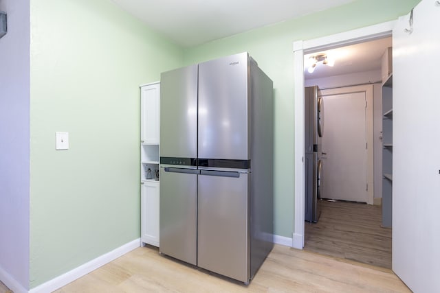 kitchen featuring light wood-style flooring, baseboards, and freestanding refrigerator