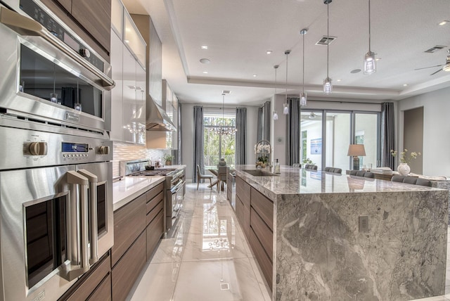 kitchen with visible vents, appliances with stainless steel finishes, a large island, modern cabinets, and a raised ceiling