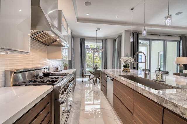 kitchen featuring marble finish floor, appliances with stainless steel finishes, a sink, modern cabinets, and wall chimney exhaust hood