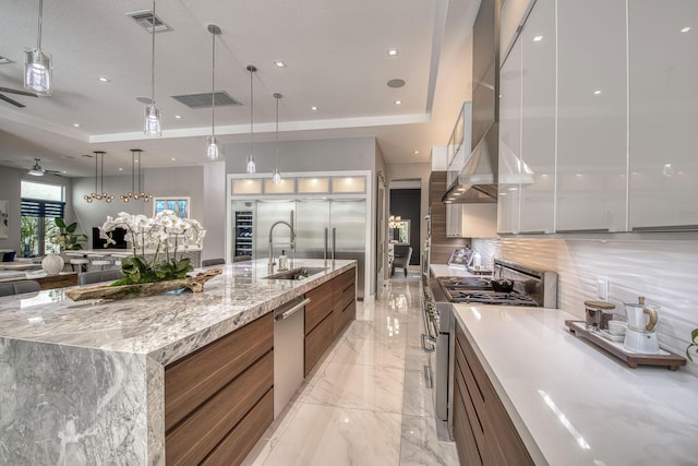 kitchen featuring visible vents, modern cabinets, appliances with stainless steel finishes, marble finish floor, and a tray ceiling