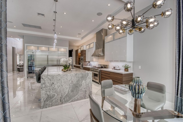 kitchen with tasteful backsplash, visible vents, double oven range, and wall chimney range hood