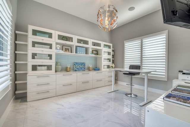 interior space featuring marble finish floor, baseboards, and an inviting chandelier