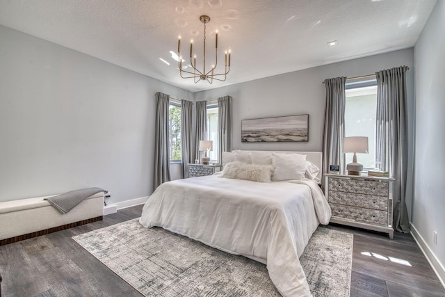 bedroom featuring baseboards, a chandelier, dark wood finished floors, and a textured ceiling