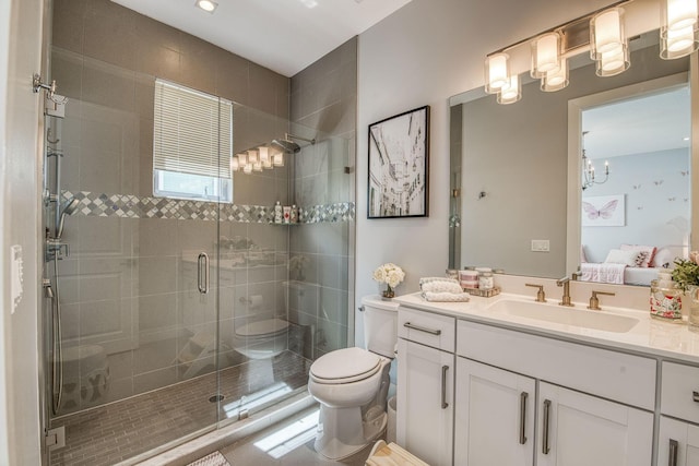 ensuite bathroom with a stall shower, toilet, ensuite bathroom, an inviting chandelier, and vanity