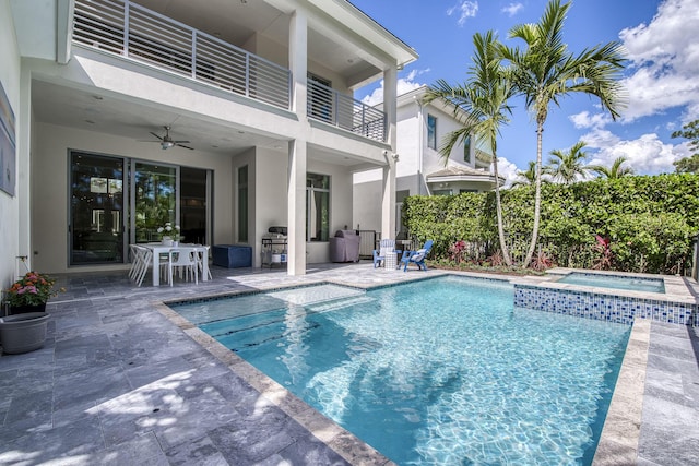 view of swimming pool with ceiling fan, a patio area, and a pool with connected hot tub