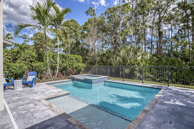 view of swimming pool featuring a patio area, fence, and a pool with connected hot tub