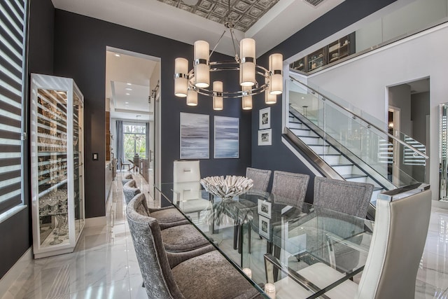 dining space with a chandelier, marble finish floor, stairway, and baseboards