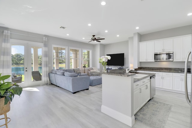 kitchen with visible vents, open floor plan, french doors, stainless steel appliances, and a sink