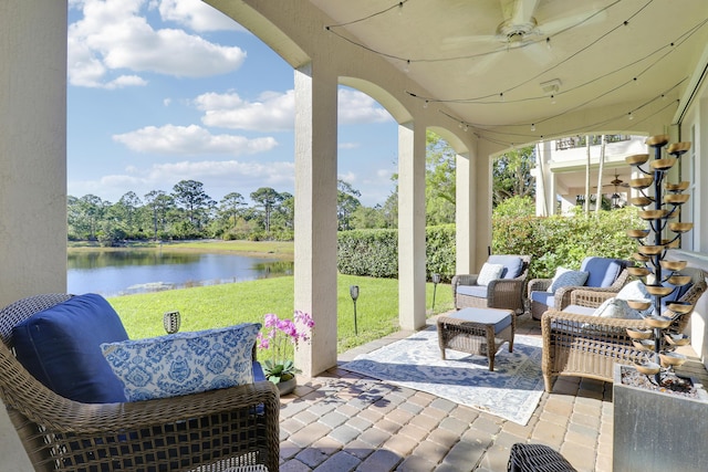 view of patio featuring a water view and ceiling fan