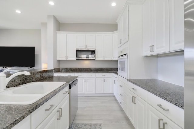 kitchen featuring a sink, white cabinets, recessed lighting, and stainless steel appliances