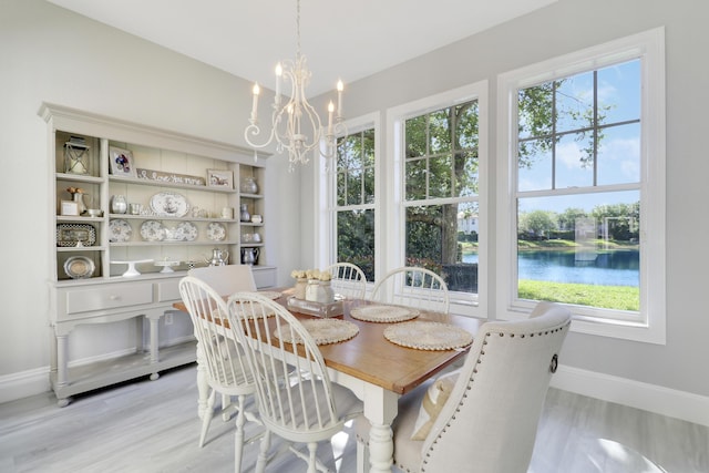 dining room featuring an inviting chandelier, baseboards, and light wood-type flooring