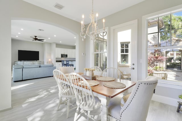 dining room featuring visible vents, baseboards, recessed lighting, arched walkways, and ceiling fan with notable chandelier