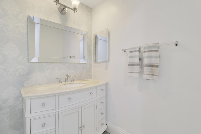 bathroom featuring wallpapered walls and vanity