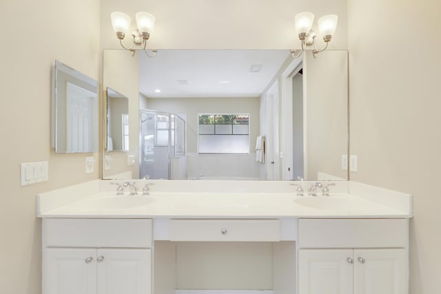 bathroom with double vanity, a shower stall, and a sink