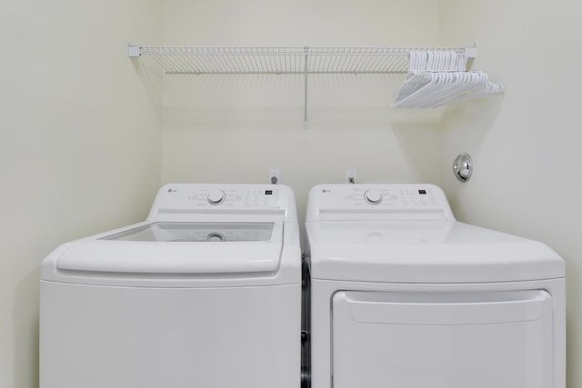 washroom with independent washer and dryer and laundry area