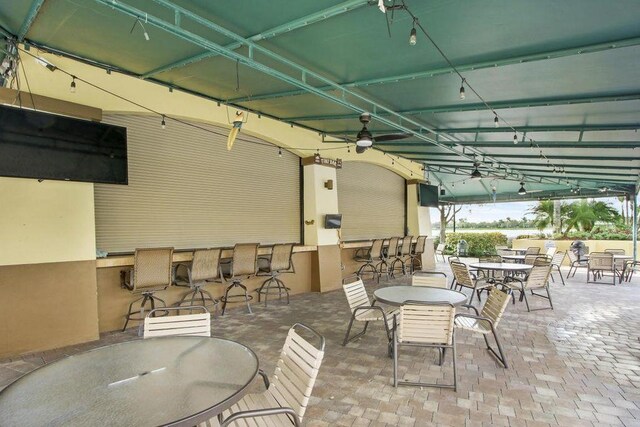 view of patio with outdoor dining space, a ceiling fan, and outdoor dry bar