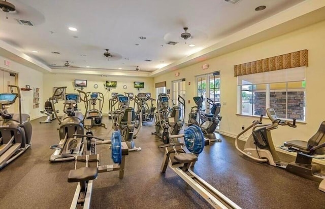 exercise room with visible vents, ceiling fan, baseboards, recessed lighting, and a raised ceiling