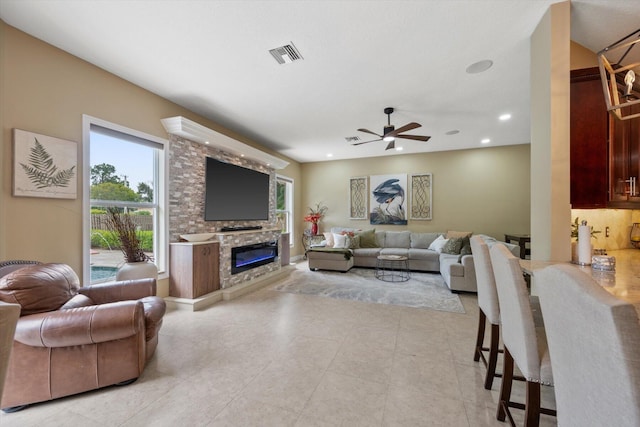 living area with a large fireplace, a ceiling fan, visible vents, and recessed lighting