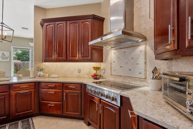 kitchen with stainless steel cooktop, wall chimney range hood, and dark brown cabinets