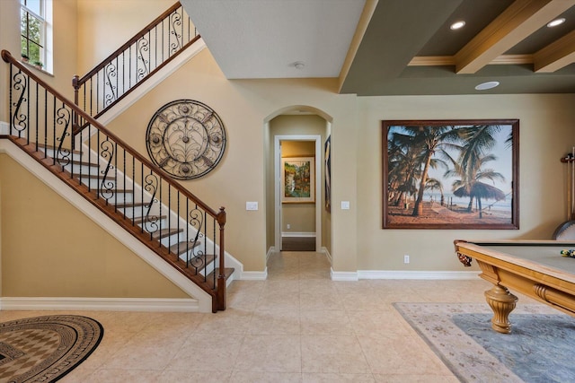 entryway featuring arched walkways, recessed lighting, a high ceiling, baseboards, and tile patterned floors