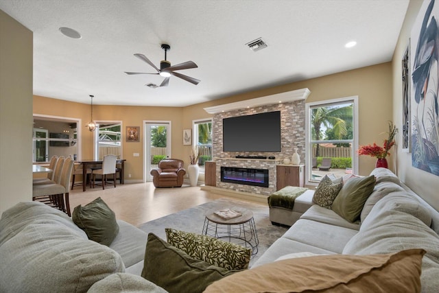 living area with recessed lighting, a ceiling fan, baseboards, visible vents, and a glass covered fireplace