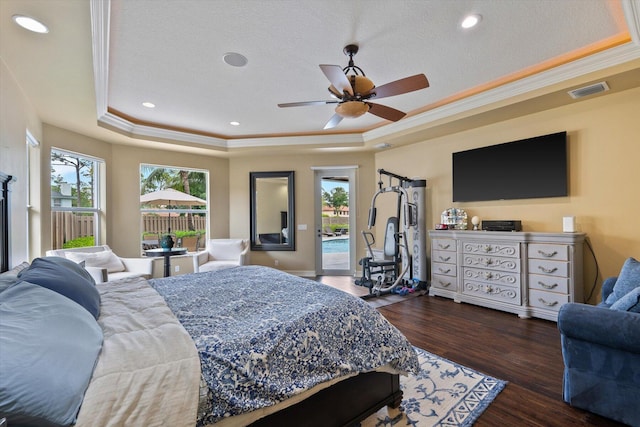 bedroom with access to outside, a tray ceiling, dark wood finished floors, and crown molding