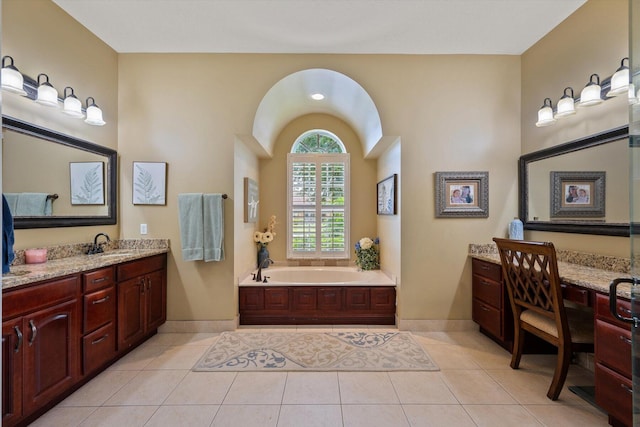 bathroom with a bath, baseboards, vanity, and tile patterned floors