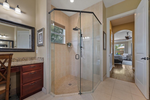 full bath featuring a stall shower, a ceiling fan, ensuite bathroom, tile patterned flooring, and vanity